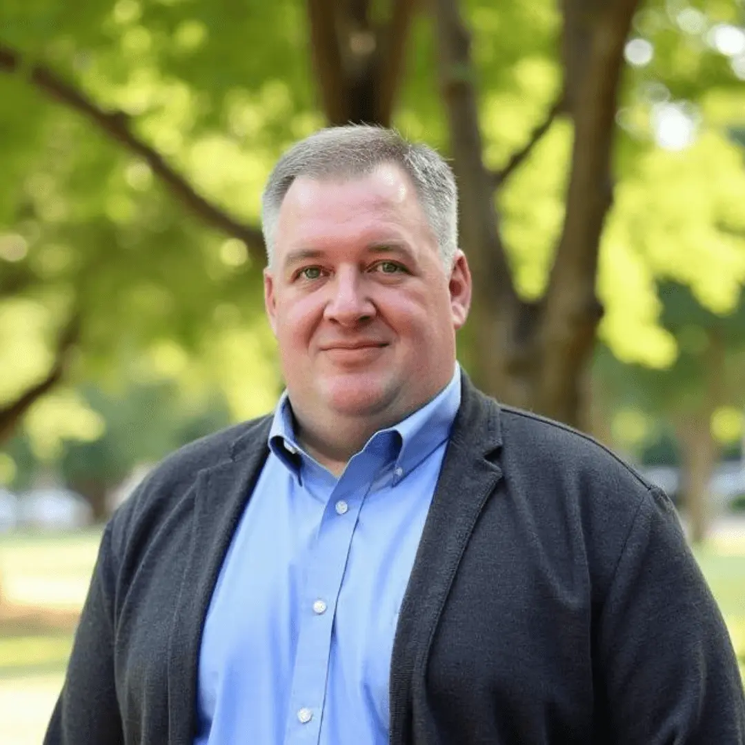 Derek Robinett headshot with trees in the background