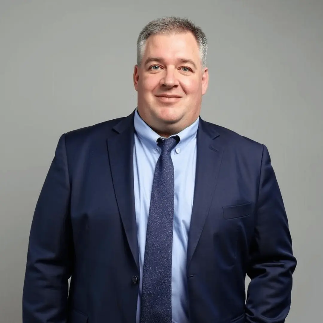 Derek Robinett against gray background with blue suit on